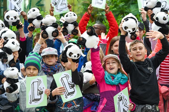 A group of children holding panda stuffed animals